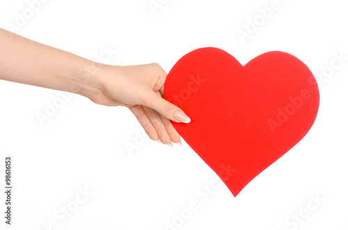 Love and greetings card theme: beautiful female hand holding a paper card red heart isolated on a white background in studio