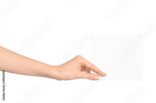 Branding and advertising theme: beautiful female hand holding a blank white paper card isolated on white background