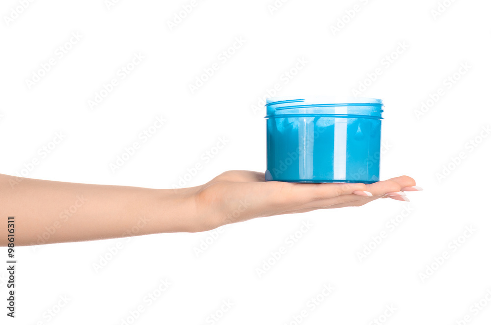 Health and body care topic: a woman's hand holding a blue jar with cream isolated on white background Health and body care topic: a woman's hand holding a blue jar with cream isolated on white background