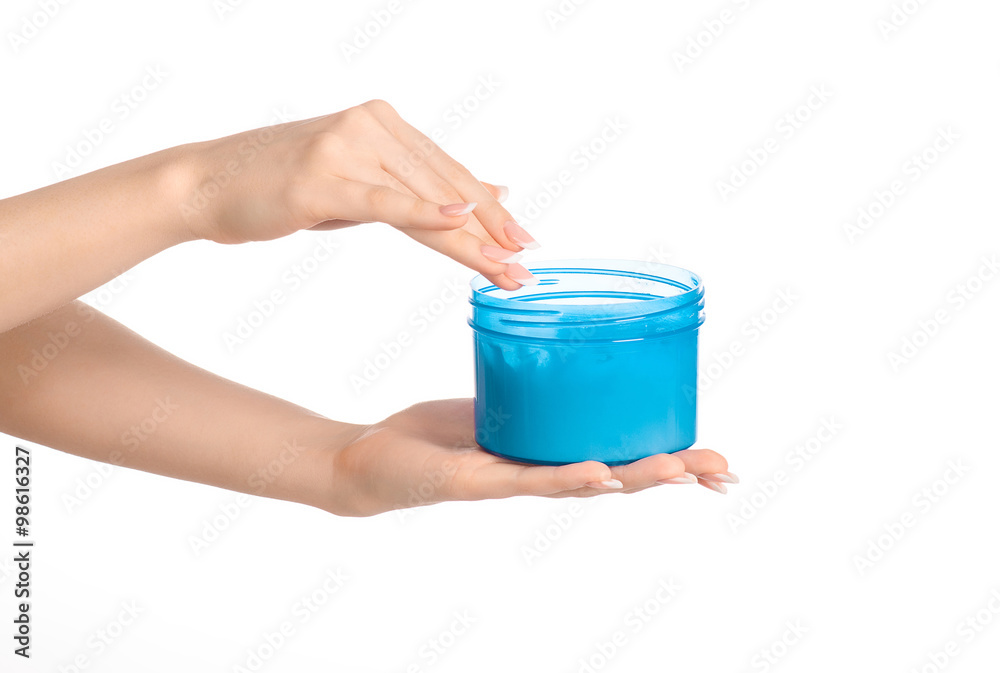 Health and body care topic: a woman's hand holding a blue jar with cream isolated on white background Health and body care topic: a woman's hand holding a blue jar with cream isolated on white background