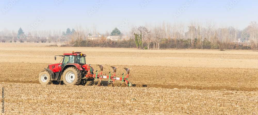 Red Tractor Plowing in Autumn. Red Tractor Plowing in Autumn.