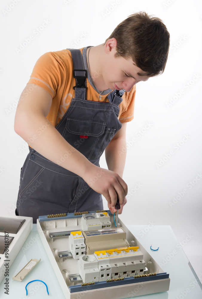 Obraz premium electrical appliance repairs. electrician fixing cable in domestic electrical box