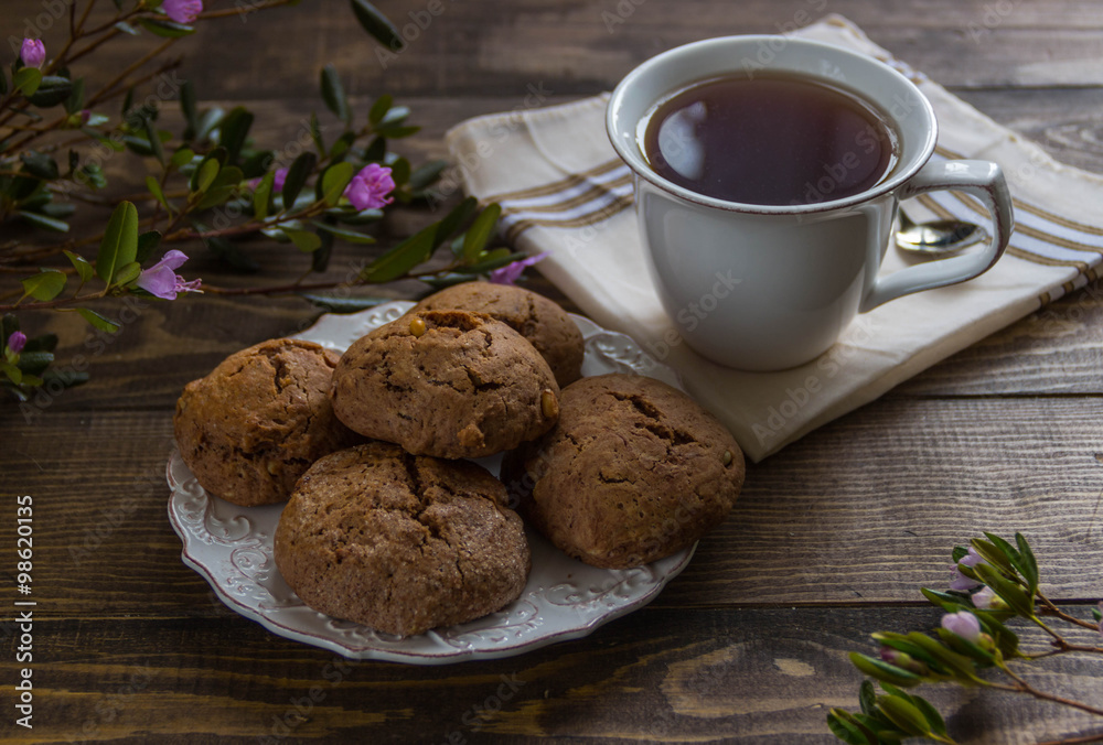 tea and cookies and fresh flowers on a wooden table tea and cookies and fresh flowers on a wooden table