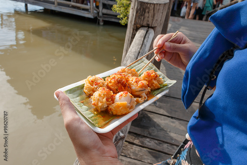 Holding mini Fried Mussels in Batter on the wood bridge ,Floating market at Ayutthaya photo