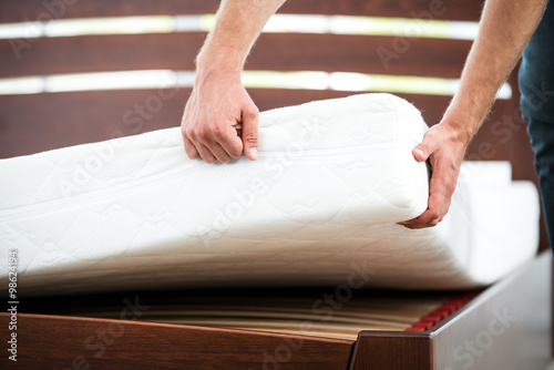 Photos Young man near white bed