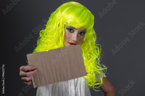 hipster, teenager with fluorescent yellow wig, carrying a cardbo photo