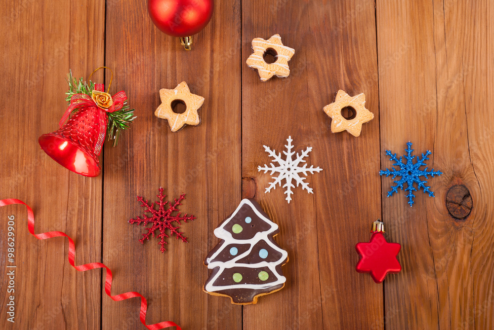 Gingerbread cookies and Christmas balls on wooden table.