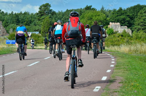group of cyclists going on the road in the countryside