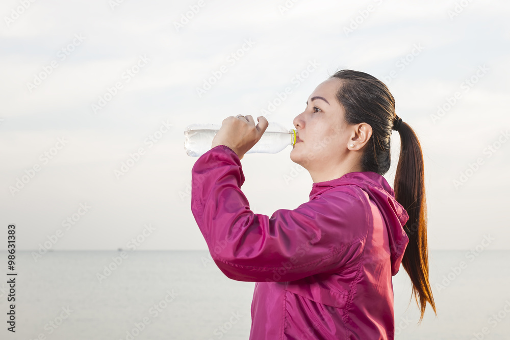 Beautiful asian girl doing exercises on the beach. against the sunset Beautiful asian girl doing exercises on the beach. against the sunset