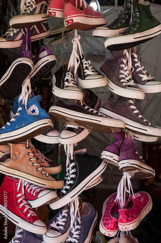 Second hand shoes hanging up for sale in the market, Thailand.