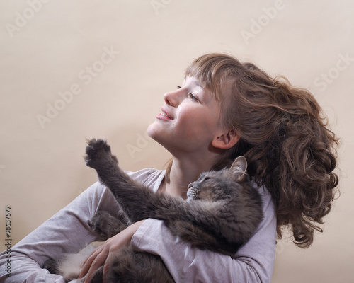 Девушка и кот. Девушка улыбается, кот протягивает лапу. Девушка и кот в хорошем настроении. У девушки красивое лицо и волосы. Кот серый, пушистый на руках у девушки