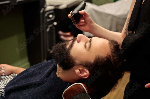 Young man cutting his beard