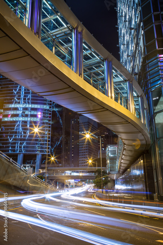 Lit modern buildings and traffic's light trails at Center in Hong Kong, China, at night.
