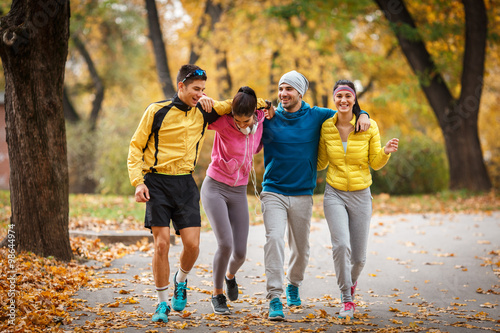 A lively group of young friends enjoys a refreshing jog in the park during the vibrant autumn season  relishing the camaraderie and the crisp  cool air.