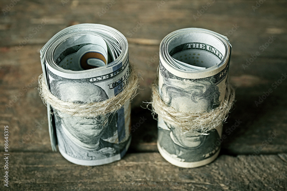 Dollars roll on wooden background Dollars roll on wooden background
