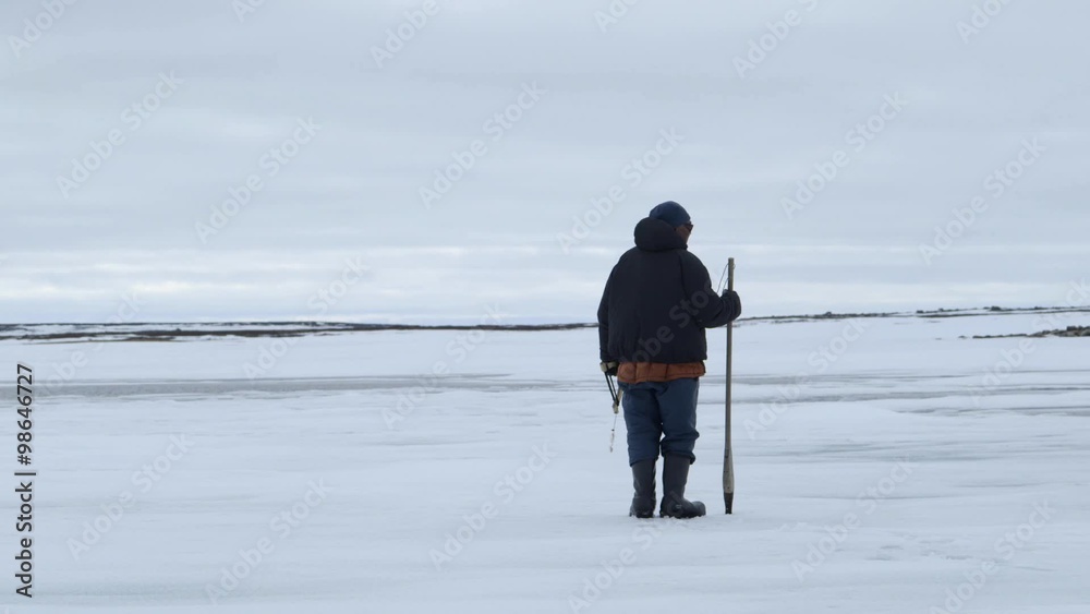 Fisherman testing ice during an arctic expedition. Fisherman testing ice during an arctic expedition.