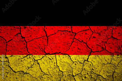 Aged old textured Germany flag. Grunge cracked soil effect used.