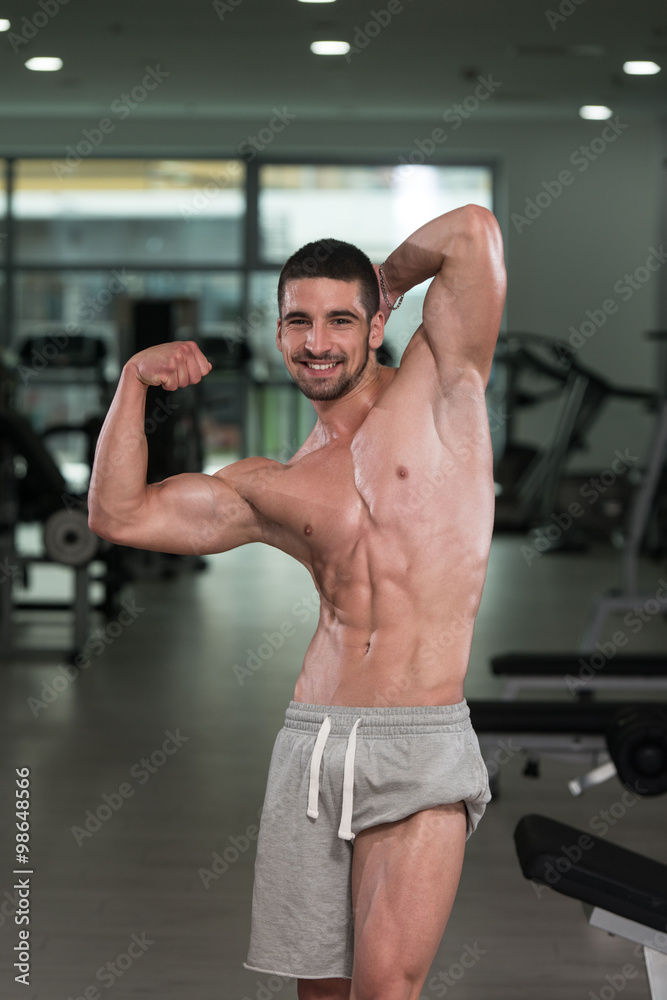 Bodybuilder Performing Rear Biceps Pose Bodybuilder Performing Rear Biceps Pose