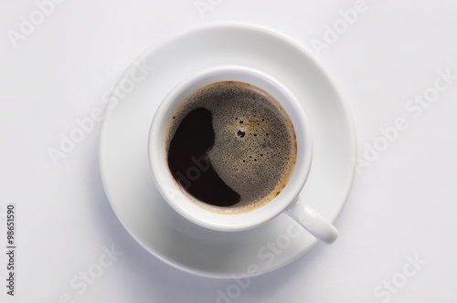 Cup of hot fresh black coffee with foam against white background viewed from top