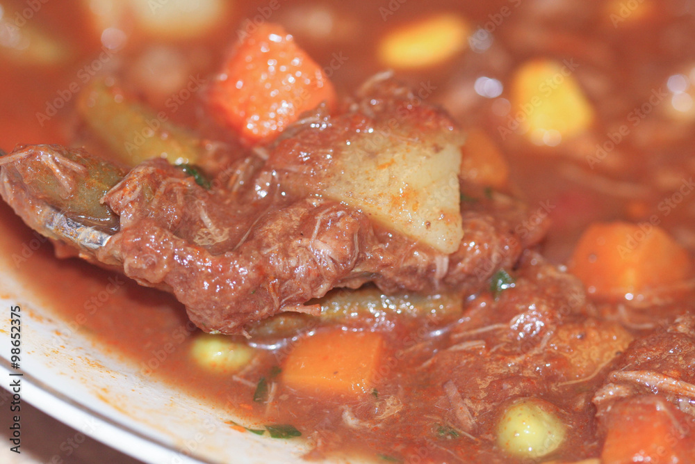 Closeup of vegetable beef soup on a spoon Closeup of vegetable beef soup on a spoon