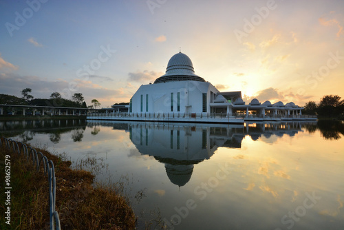 Beautiful cloudy sunrise over white floating mosque located at Seri Iskandar, Ipoh, Perak, Malaysia.