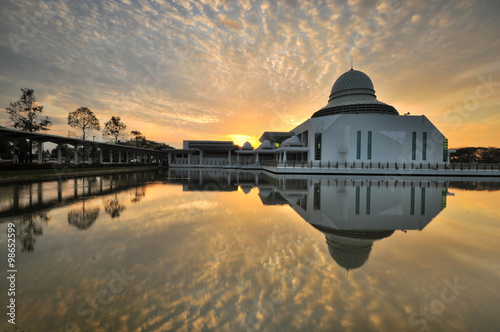 Beautiful cloudy sunrise over white floating mosque located at Seri Iskandar, Ipoh, Perak, Malaysia.