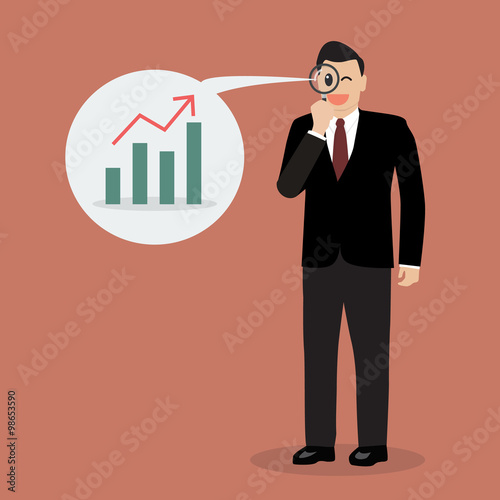 Businessman looking through a magnifying glass for business futu