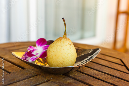 pair and pink orchid in the bowl on the lath table, pair fruit
