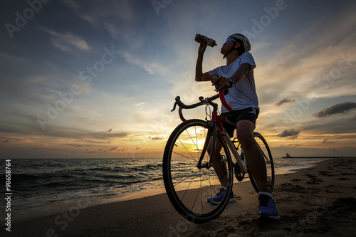 Drinking, cycling concept outdoors against sunset