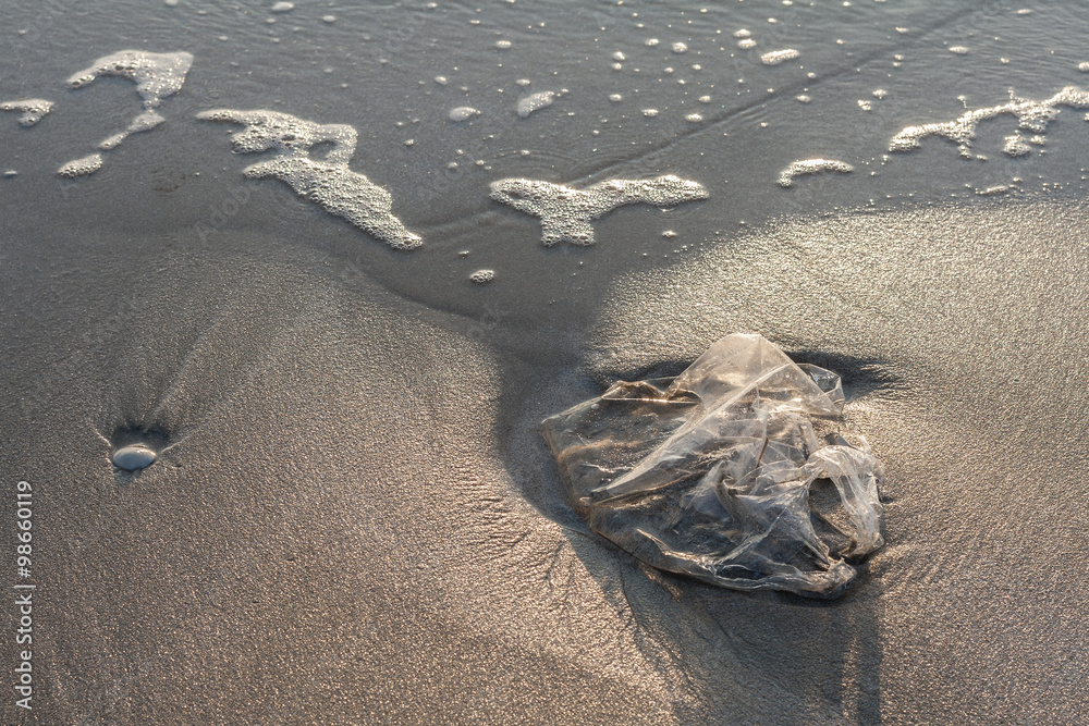 Obraz premium Used plastic bag garbage on sand beach