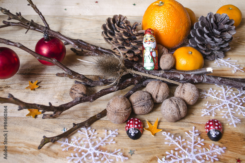 Chocolate, citrus fruits,nuts with cones and toys on boards
