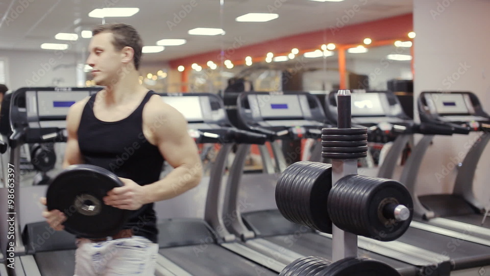 Bodybuilder change weight on barbell in the gym Bodybuilder change weight on barbell in the gym