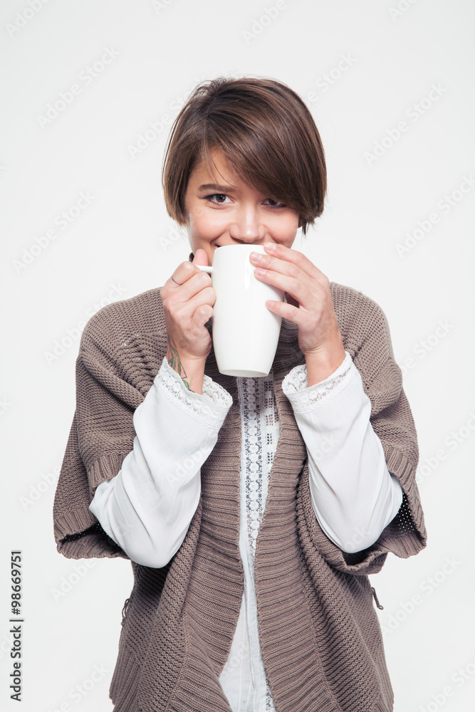 Pretty smiling young woman in knitted jacket drinking tea Pretty smiling young woman in knitted jacket drinking tea
