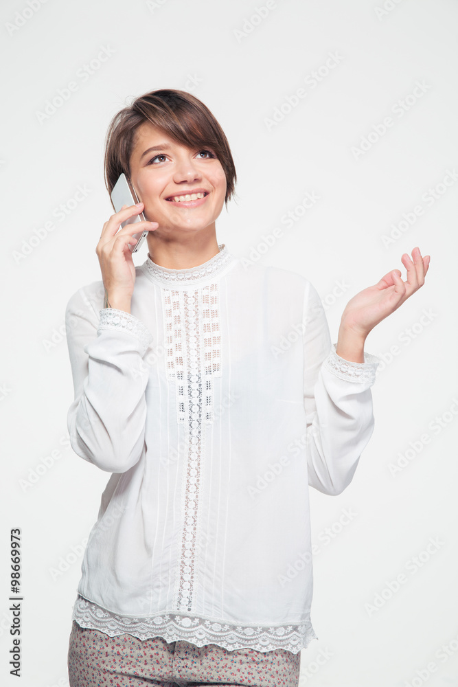 Beautiful joyful young woman standing and talking on cell phone Beautiful joyful young woman standing and talking on cell phone