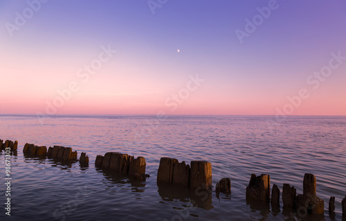 Pillars in water at sunset