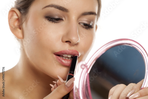 beautiful young woman apply lipstick