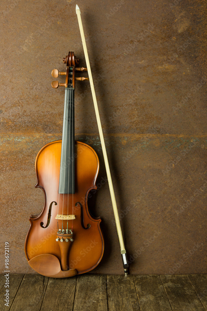 vintage violin resting against an old steel background