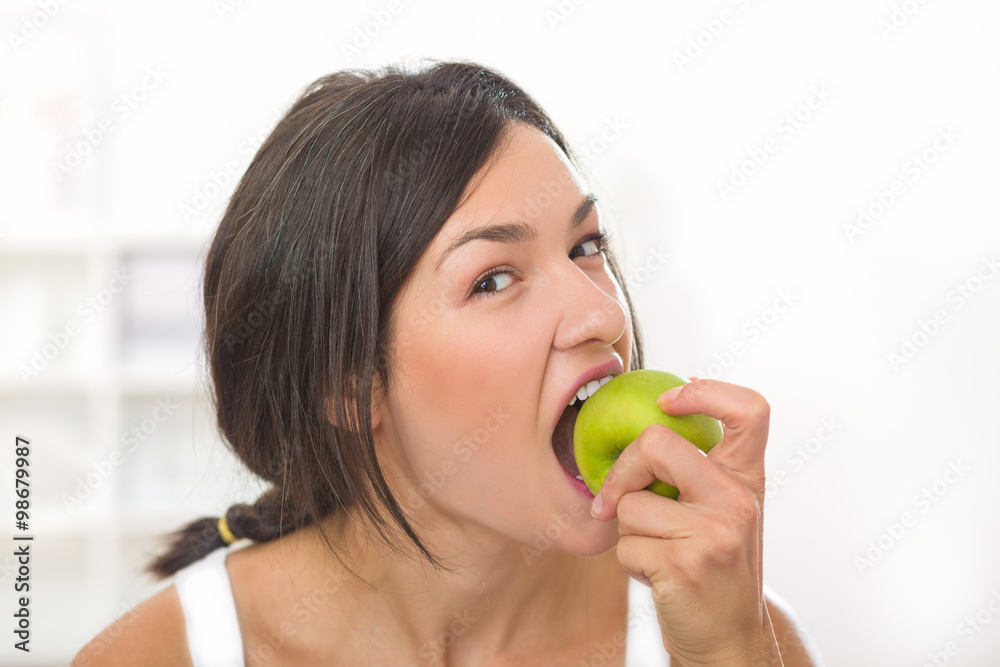 Beautiful girl taking a bite of apple and looking at the camera Beautiful girl taking a bite of apple and looking at the camera