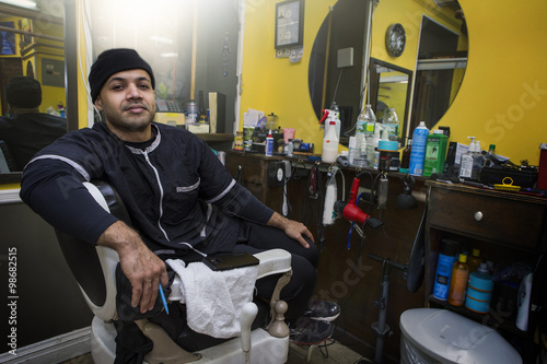 Barber posing in his shop.