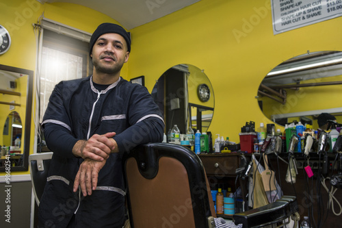 Barber posing in his shop.