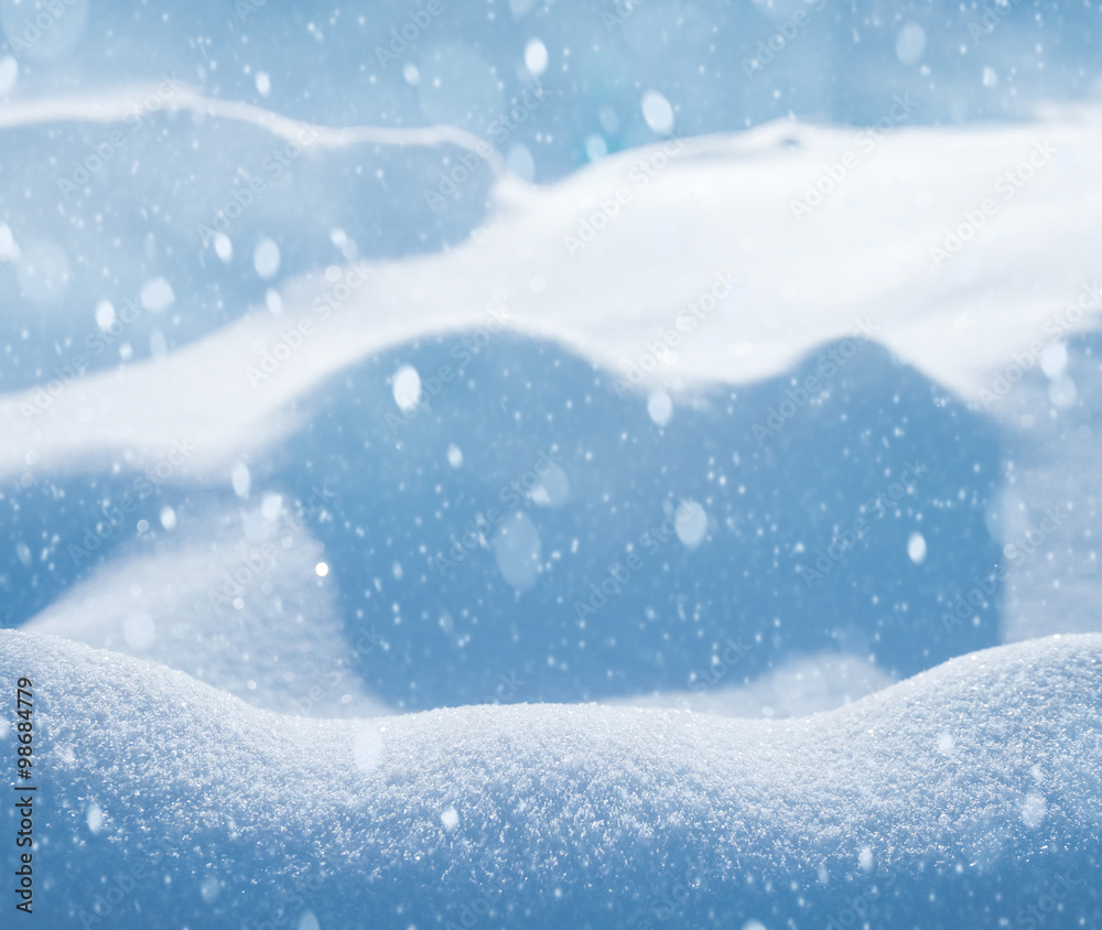 Natural winter background with snow drifts and falling snow