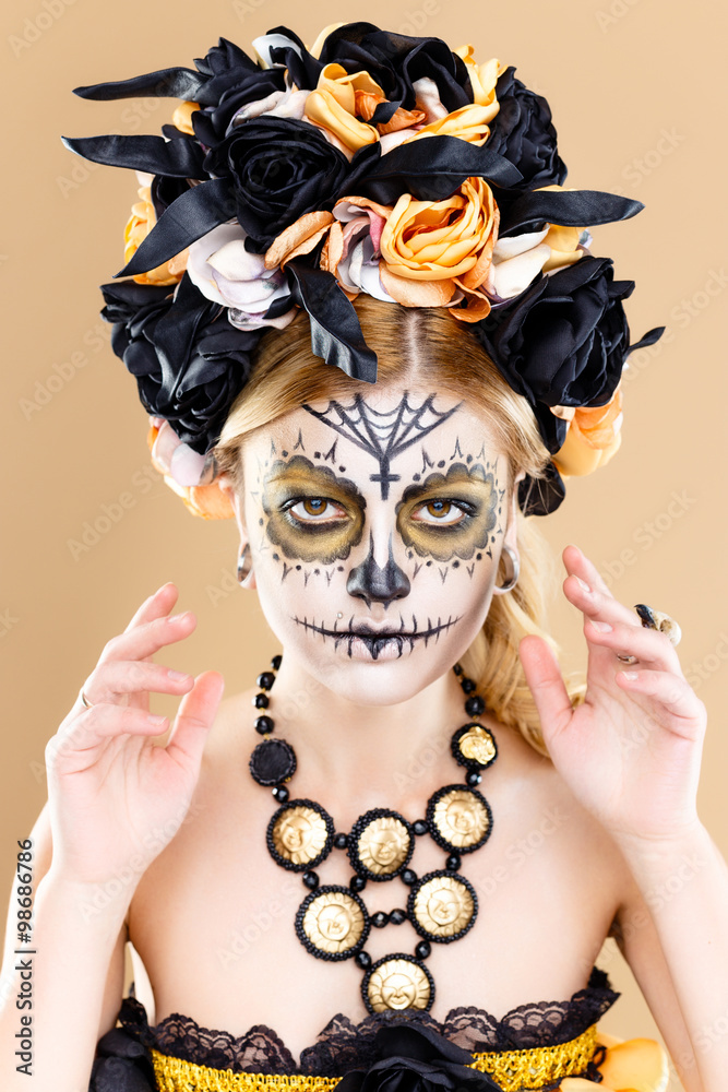attractive young woman with sugar skull makeup,Dia de los Muertos - Mexican Day of the dead woman wearing sugar skull makeup and flower wreath.