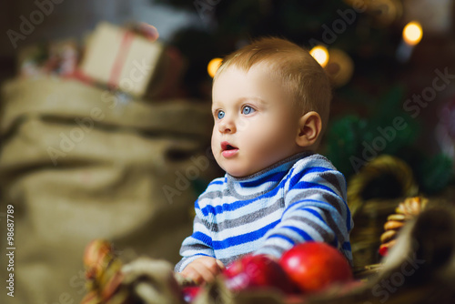 one years old child celebrating holidays near Christmas tree