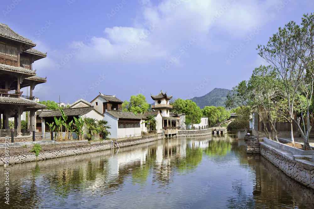 Traditional white Chinese houses reflected in a tranquil canal, Hengdian, China Traditional white Chinese houses reflected in a tranquil canal, Hengdian, China