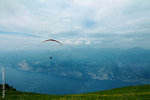 Paraglider over lake and mountains