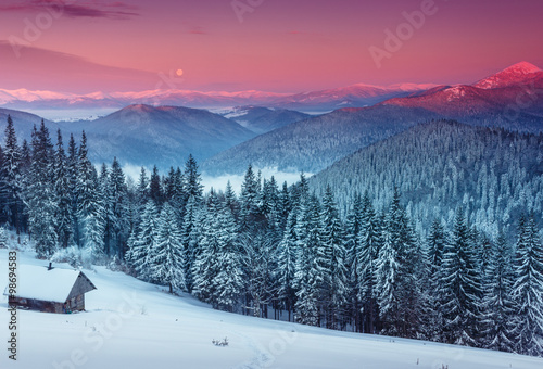 Colorful winter morning in the mountains. View of the moon and the snow-capped peaks. © vovik_mar