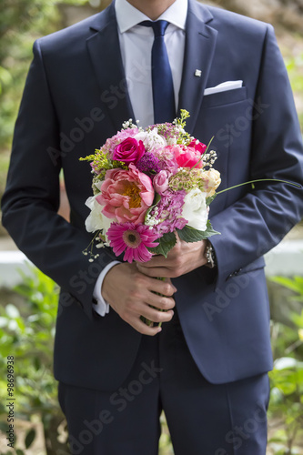 well-dressed man holding a bouquet of flowers. Holidays and cele