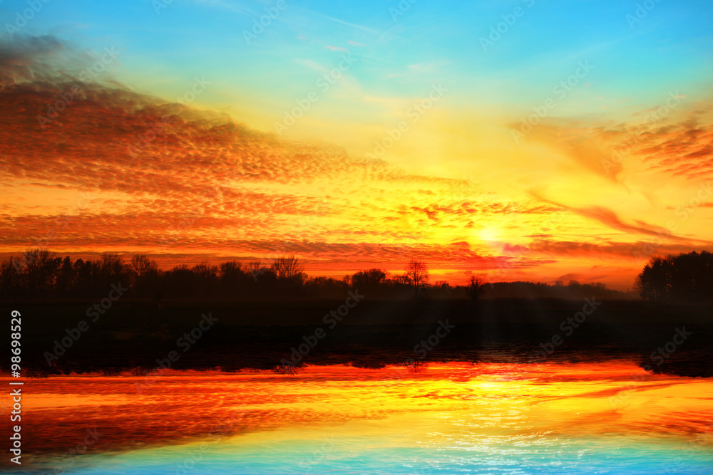 Kolorowy zachód słońca z odbiciem w jeziorze.