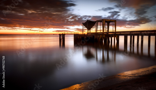 Ancient industrial pier over a sunrise