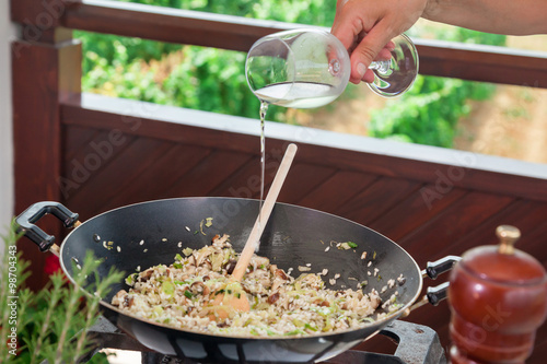 Simmering food in wok and adding wine.